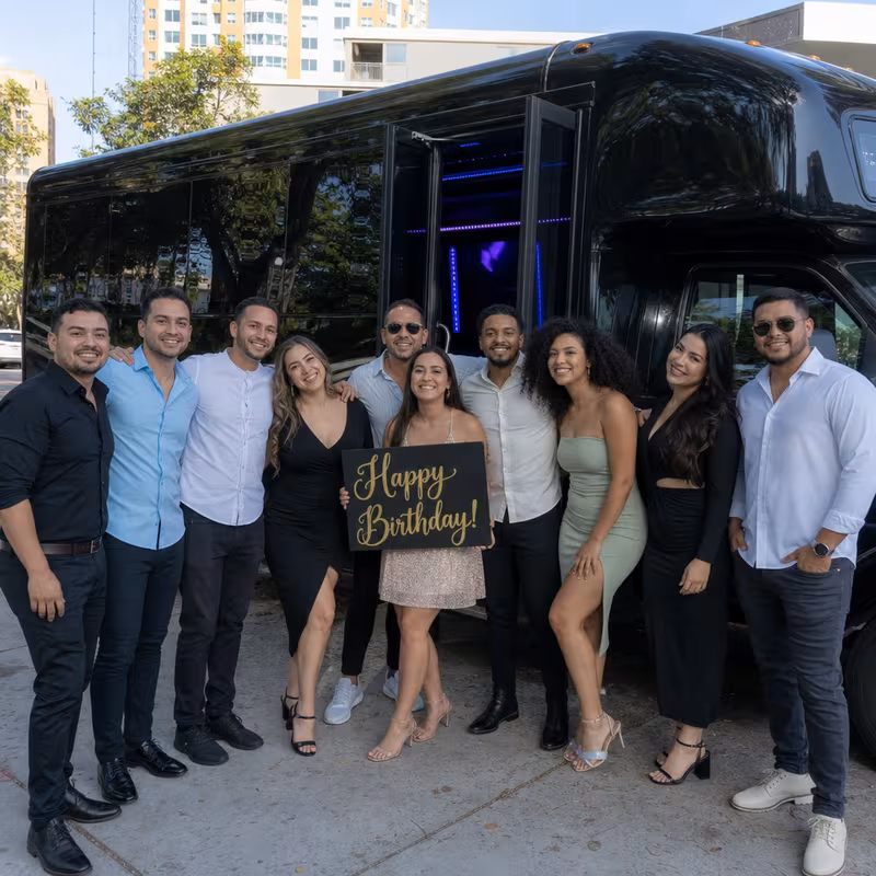 Group boarding a white charter bus for Birthday Transportation transportation in New Orleans
