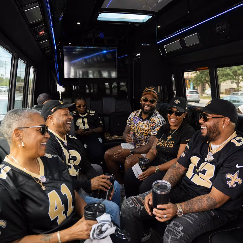 Group boarding a white charter bus for Sporting Event Transportation transportation in New Orleans